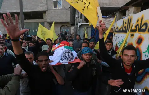 Mourners carry the body of Palestinian Hani Wahdan, 22, who, according to medics, was killed by Israeli troops during clashes with Palestinian protesters on Friday, during his funeral in Gaza City December 26, 2015. Phot...