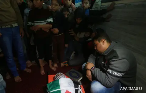 Mourners carry the body of Palestinian Hani Wahdan, 22, who, according to medics, was killed by Israeli troops during clashes with Palestinian protesters on Friday, during his funeral in Gaza City December 26, 2015. Phot...