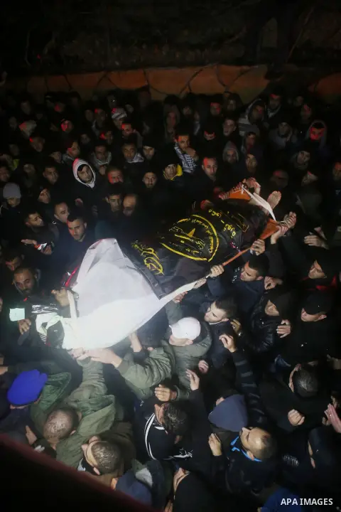 Palestinian men carry a body of a Palestinian alleged attacker upon its release by the Israeli security forces in the West Bank city of Ramallah, on December 31, 2015. Israeli authorities turned over a number of bodies t...