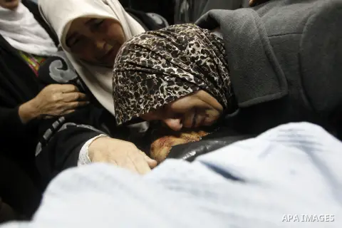 The mother of 18-year-old Palestinian Ahmad Younis Kawazba kisses his head at a hospital in the West Bank city of Hebron on Jan. 05, 2016. Kawazba was shot dead after he reportedly stabbed an Israeli soldier at the Gush...