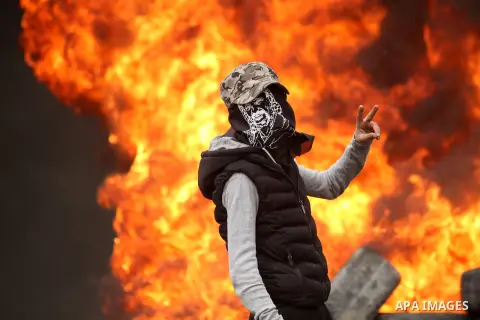 A Palestinian protester flashes victory sign during clashes with Israeli security forces following a protest against the expropriation of Palestinian land by Israel in the West Bank village of Kafr Qaddum, near the north...