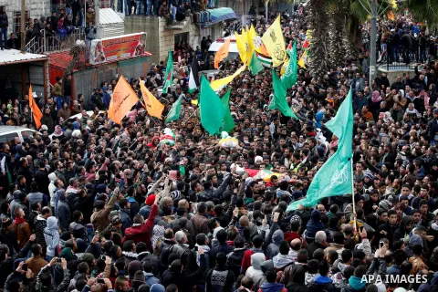 Mourners carry the bodies of four Palestinians, who were killed by Israeli security forces after they perpetrated attacks in the southern West Bank, during their funeral in the West Bank village of Sair on January 9, 201...