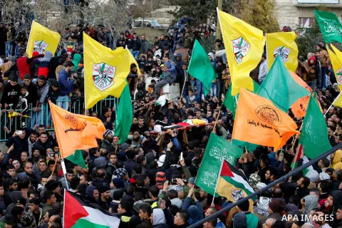Mourners carry the bodies of four Palestinians, who were killed by Israeli security forces after they perpetrated attacks in the southern West Bank, during their funeral in the West Bank village of Sair on January 9, 201...