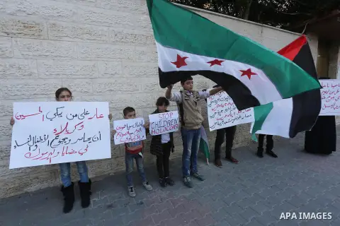 Palestinians hold banners during a protest to show solidarity with the Syrians of Madaya on hunger caused by the siege, in front of Red cross office, in Gaza city on January 12, 2016. Photo by Mohammed Asad