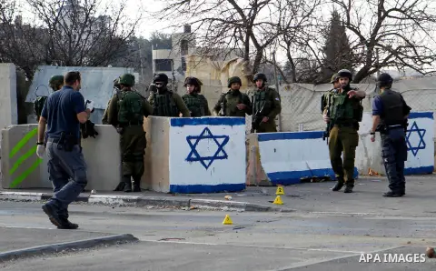 Israeli soldiers stand guard near the scene where two Palestinian men were shot dead by Israeli troops at the Beit Ainun junction northeast of Hebron in the occupied West Bank on Jan. 12, 2016. An Israeli army spokespers...