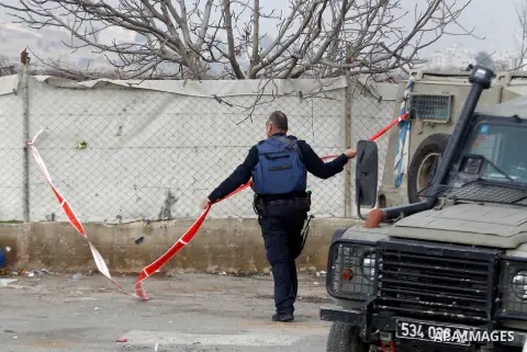 An Israeli forensic policeman gathers evidence at the site of a stabbing attack at the Beit Ainun junction near Hebron on January 14, 2016. Israeli forces Thursday shot and killed a Palestinian near the Beit Ainun juncti...