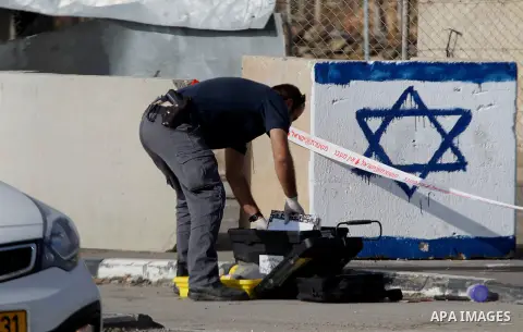 An Israeli forensic policeman gathers evidence at the site of a stabbing attack at the Beit Ainun junction near Hebron on January 14, 2016. Israeli forces Thursday shot and killed a Palestinian near the Beit Ainun juncti...