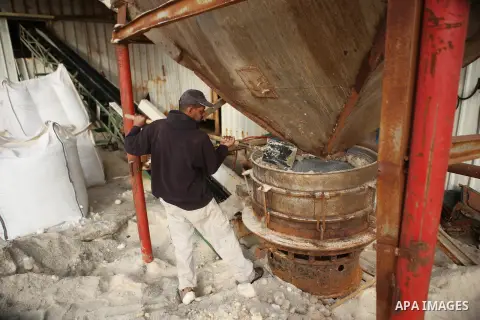 A Palestinian worker extracts salt from the Dead Sea, at his factory, in the West Bank city of Jericho on January 14, 2016. The Dead Sea also called the Salt Sea, is a salt lake with borders to Jordan in the east and the...