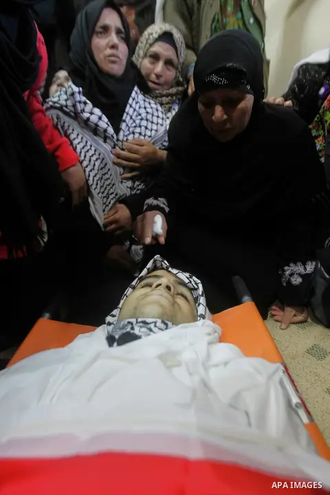 Relatives of the Palestinian Moayad al-Jabreen mourns over his body during his funeral in the West Bank village of Sair, east of Hebron, on January 15, 2016. The 20-year-old man was shot dead the previous day by Israeli...
