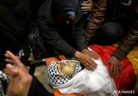 Relatives of the Palestinian Moayad al-Jabreen mourns over his body during his funeral in the West Bank village of Sair, east of Hebron, on January 15, 2016. The 20-year-old man was shot dead the previous day by Israeli...