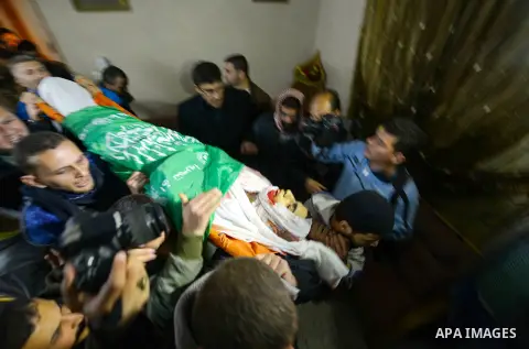 Palestinian mourners carry the body of Mohammed Abu Zaida, who died after being shot in the neck by Israeli security forces at a protest, during his funeral in the Bureij refugee camp in central Gaza, on January 15, 2016...