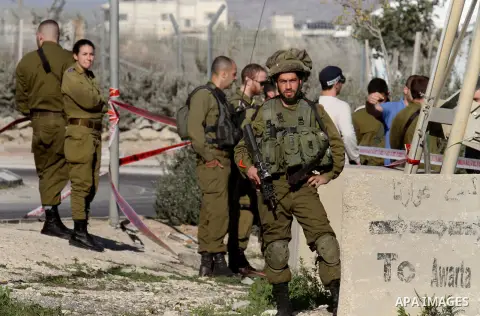 Israeli security forces gather near the scene where a Palestinian man was shot dead following a reported stabbing attack at the Hawara checkpoint, south of the West Bank city of Nablus, on Jan. 17, 2016. Israeli army Sun...