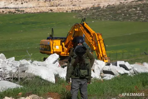 Israeli border policemen stand guard during the demolition of a Palestinian house under the order of the Israeli army, in the West Bank town of Dura, south of Hebron January 20, 2016. The owners of the house said they we...