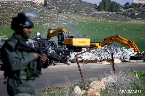 An Israeli border policeman stands guard during the demolition of a Palestinian house under the order of the Israeli army, in the West Bank town of Dura, south of Hebron January 20, 2016. The owners of the house said the...