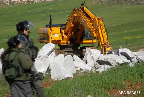 Israeli border policemen stand guard during the demolition of a Palestinian house under the order of the Israeli army, in the West Bank town of Dura, south of Hebron January 20, 2016. The owners of the house said they we...