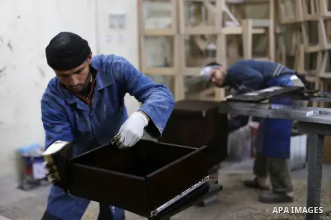 Palestinians disabled work on wood to make furniture during participate in a project titled "Erada" funded by the Turkish President Ragab Ardogan at the Islamic university, in Gaza City, on January 20, 2016. Photo by Moh...