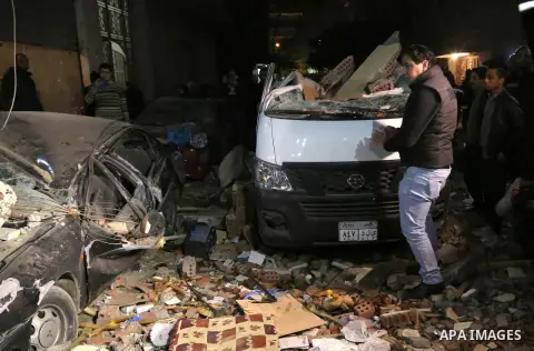 Egyptians gather at the scene of a bomb blast in a main street in Giza on January 21, 2016. A bomb attack killed six people, including three policemen, on Thursday near a road leading to the pyramids in the Cairo suburb...