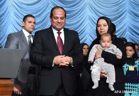 Egyptian President Abdel-Fattah el-Sissi poses for a photo with families of policemen killed in militant attacks, at a ceremony marking Police Day, which falls on Jan. 25, the anniversary of the 2011 uprising that topple...