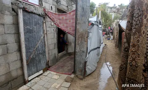 A Palestinian boy looks out his family house on a rainy day, in Khan Younis in the southern Gaza Strip, January 24, 2016. Photo by Yasser Qudih