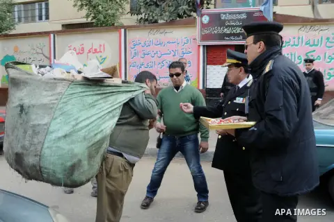 Egyptian policemen give out chocolates to citizens on Cairo's landmark Tahrir Square on January 25, 2016, as the country marks the fifth anniversary of the 2011 uprising. Egyptians marked the fifth anniversary of the upr...