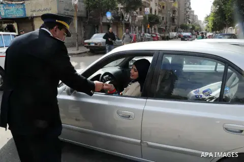 Egyptian policemen give out chocolates to citizens on Cairo's landmark Tahrir Square on January 25, 2016, as the country marks the fifth anniversary of the 2011 uprising. Egyptians marked the fifth anniversary of the upr...
