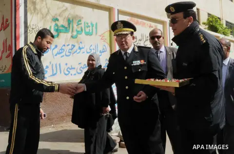 Egyptian policemen give out chocolates to citizens on Cairo's landmark Tahrir Square on January 25, 2016, as the country marks the fifth anniversary of the 2011 uprising. Egyptians marked the fifth anniversary of the upr...