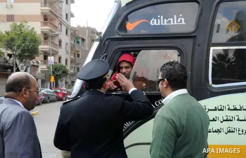 Egyptian policemen give out chocolates to citizens on Cairo's landmark Tahrir Square on January 25, 2016, as the country marks the fifth anniversary of the 2011 uprising. Egyptians marked the fifth anniversary of the upr...