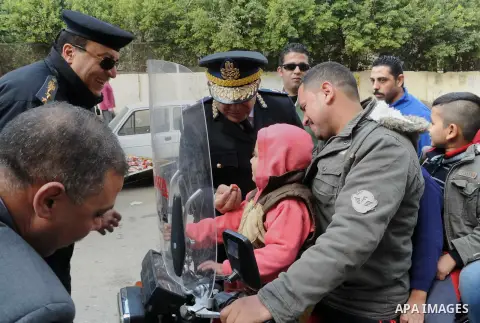 Egyptian policemen give out chocolates to citizens on Cairo's landmark Tahrir Square on January 25, 2016, as the country marks the fifth anniversary of the 2011 uprising. Egyptians marked the fifth anniversary of the upr...