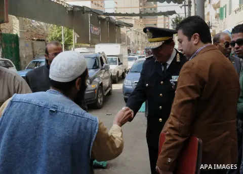Egyptian policemen give out chocolates to citizens on Cairo's landmark Tahrir Square on January 25, 2016, as the country marks the fifth anniversary of the 2011 uprising. Egyptians marked the fifth anniversary of the upr...