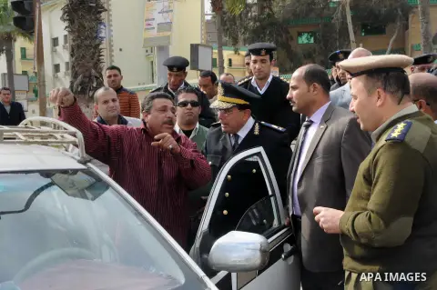 Egyptian policemen give out chocolates to citizens on Cairo's landmark Tahrir Square on January 25, 2016, as the country marks the fifth anniversary of the 2011 uprising. Egyptians marked the fifth anniversary of the upr...