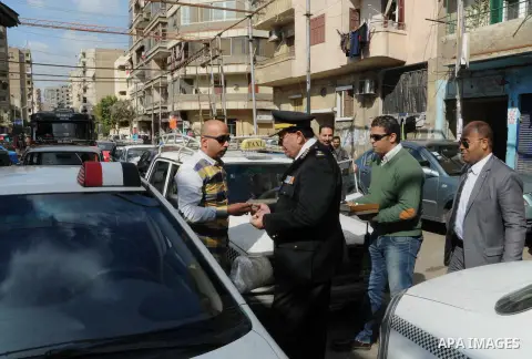 Egyptian policemen give out chocolates to citizens on Cairo's landmark Tahrir Square on January 25, 2016, as the country marks the fifth anniversary of the 2011 uprising. Egyptians marked the fifth anniversary of the upr...