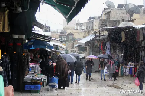 Palestinians walk at a street on a rainy day in Jerusalem's Old city, on Jan. 25, 2016. Photo by Mahfouz Abu Turk
