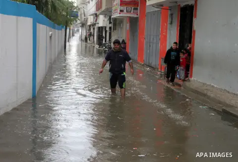 A Palestinian man crosses a road flooded with rainwater following heavy rains, in Rafah in the southern Gaza Strip January 25, 2016. Photo by Abed Rahim Khatib