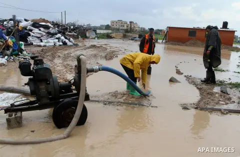Members of Palestinian Civil Defence work in a flooded street with sewage during a winter storm in the southern Gaza Strip town of Khan Younis on January 25, 2016. Photo by Abed Rahim Khatib