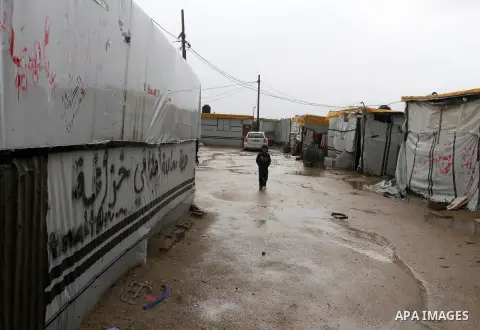 A Palestinian child walks past temporary housing during a winter storm in the southern Gaza Strip town of Khan Younis on January 25, 2016. Photo by Abed Rahim Khatib