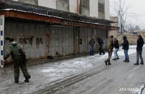 Israeli soldiers forces stand guard despite of the snow during a snowstorm in the West Bank city of Hebron, on January 26, 2016. Photo by Wisam Hashlamoun