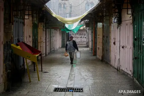 Palestinians walk during a snowstorm in the West Bank city of Hebron, on January 26, 2016. Photo by Wisam Hashlamoun