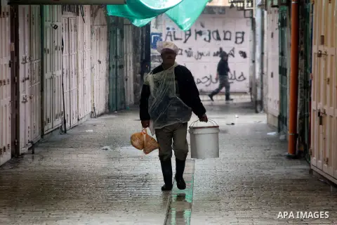 Palestinians walk during a snowstorm in the West Bank city of Hebron, on January 26, 2016. Photo by Wisam Hashlamoun