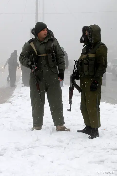 Palestinian National Security stand as they help citizens during a snowstorm in the West Bank city of Hebron, on January 26, 2016. Photo by Wisam Hashlamoun