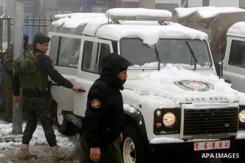 Palestinian National Security stand as they help citizens during a snowstorm in the West Bank city of Hebron, on January 26, 2016. Photo by Wisam Hashlamoun
