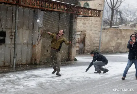 Israeli security forces play with snow during a snowstorm in the West Bank city of Hebron, on January 26, 2016. Photo by Wisam Hashlamoun