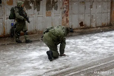 Israeli security forces play with snow during a snowstorm in the West Bank city of Hebron, on January 26, 2016. Photo by Wisam Hashlamoun