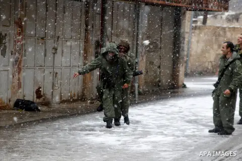 Israeli security forces play with snow during a snowstorm in the West Bank city of Hebron, on January 26, 2016. Photo by Wisam Hashlamoun
