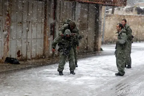 Israeli security forces play with snow during a snowstorm in the West Bank city of Hebron, on January 26, 2016. Photo by Wisam Hashlamoun