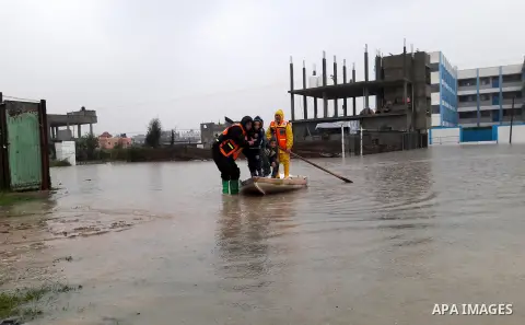 Palestinian Civil Defence workers use a stand-up kayak to evacuate people from a flooded area following heavy rainfall in the southern Gaza Strip town of Rafah on January 26, 2016. Photo by Abed Rahim Khatib