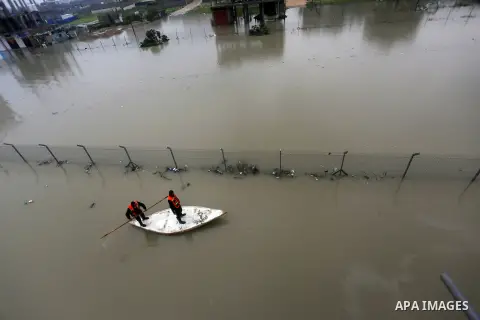 Palestinian Civil Defence workers use a stand-up kayak to evacuate people from a flooded area following heavy rainfall in Rafah in the southern Gaza Strip January 27, 2016. Photo by Yasser Qudih