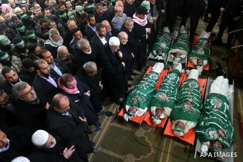 Palestinians pray at a mosque near the bodies of the seven Palestinian Hamas militants whom killed after a tunnel, built for fighting Israel, collapsed in the Gaza Strip, during their funeral in Gaza City on January 29,...