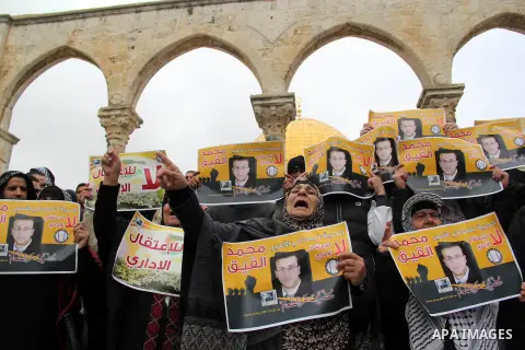Palestinians hold posters bearing a portrait of Palestinian journalist Mohammed al-Qiq who is imprisoned in an Israeli jail during a protest in support of his hunger strike in front of Jerusalem's Dome of the Rock mosque...