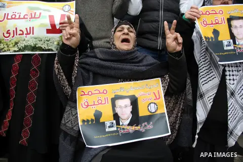 Palestinians hold posters bearing a portrait of Palestinian journalist Mohammed al-Qiq who is imprisoned in an Israeli jail during a protest in support of his hunger strike in front of Jerusalem's Dome of the Rock mosque...