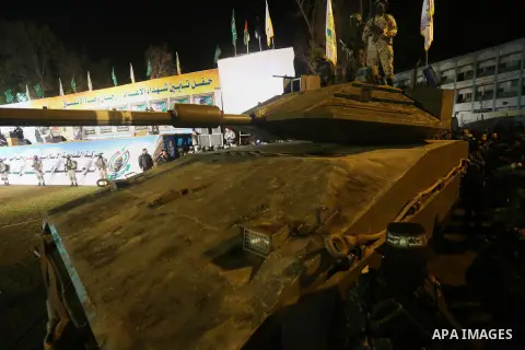 Palestinian members of the Ezzedine al-Qassam Brigades, the armed wing of the Hamas movement, gather around a mock Israeli tank on January 31, 2016 in Gaza city during a gathering to pay tribute to the brigade's militant...
